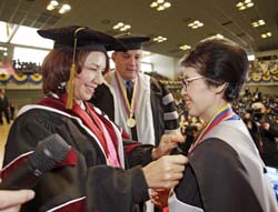 Dr. Gil pins Mrs. Ikeda with the UBA badge