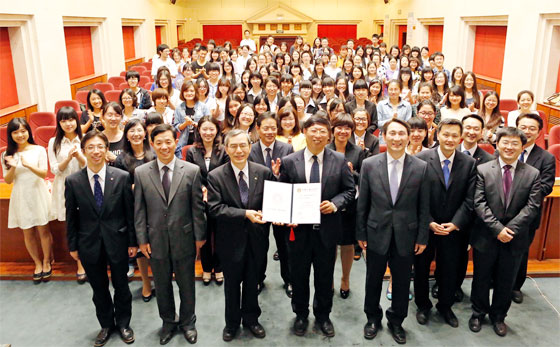 天津外国语大学修刚校长（前排中间）交托“名誉教授”证书给代表池田SGI会长接受的创价大学马场校长（左三）