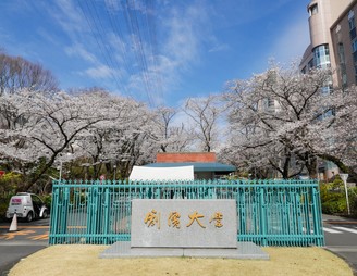 創價大學正門的石碑刻著教育家暨創價學會第一任會長牧口常三郎的字跡「創價大學」（東京，八王子）