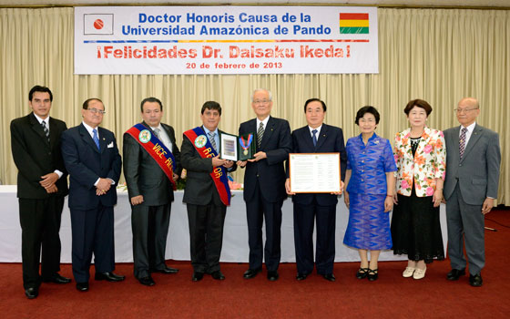 El rector Ludwing Arciénega (4.° de la izq.) deposita los símbolos honoríficos en manos del representante de Daisaku Ikeda.